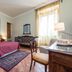 La Gemma Di Elena in Lucca: guest room with bed, sofa, desk, and tall window with sheer curtains
