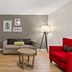 Country Inn & Suites by Radisson, Roanoke, VA room with sofa, TV, floor lamp and red armchair