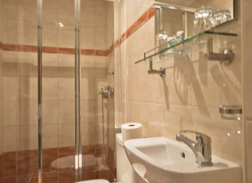 Mirabello Hotel Heraklion bathroom with glass shower, sink, and glass shelf