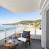 Pacific Edge Hotel in Laguna Beach balcony with ocean view, glass railing, and chair overlooking the beach