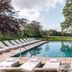 The Alfriston in Polegate with an outdoor pool and sun loungers in a landscaped garden