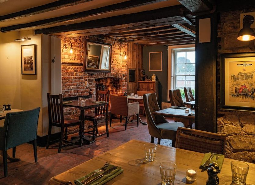 The Royal Oak in Chichester, cozy brick-pub dining room with wood beams and window seating