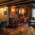 The Royal Oak in Chichester, cozy brick-pub dining room with wood beams and window seating