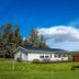 Vallakot Farm Guesthouse in Laugar, single-story guesthouse with green lawn and open countryside