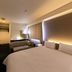 Plaza Hotel Toyota guest room with king bed, sofa and large window blinds in Toyota
