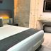 Illusion Xpress I Attraction Hotel Deluxe room in Playa del Carmen with king bed and stone bathroom wall
