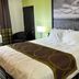 Super 8 by Wyndham Nebraska City guest room with king bed, bedside lamp and black-and-white wall art