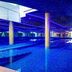 Atrium Hotel Heathrow in Hounslow: blue-lit indoor pool with mirrored reflections and columns