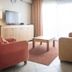 Studio's De Vlijt Texel living room in De Cocksdorp with armchairs, TV, coffee table and bright balcony doors
