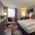Fürther Hotel Mercure Nürnberg West room in Fürth with king bed, desk, sofa and window light