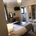 Ben Nevis Guest House bedroom in Fort William with bed, wall-mounted TV, vanity and open wardrobe