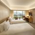 Conrad Singapore Orchard guest room with twin beds, desk, and city view in Singapore