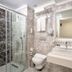 Grand Uysal Apart Hotel Alanya bathroom with glass shower, sink, toilet, and wall mirror