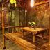 Patria Garden Hotel Blitar rustic bamboo seating area with tables and stone wall