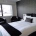 Abode On Courtenay Motor Inn, New Plymouth guest room with queen bed, window and black chairs