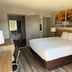 Days Inn by Wyndham Cookeville guest room with king bed, desk, lamps and bathroom entry