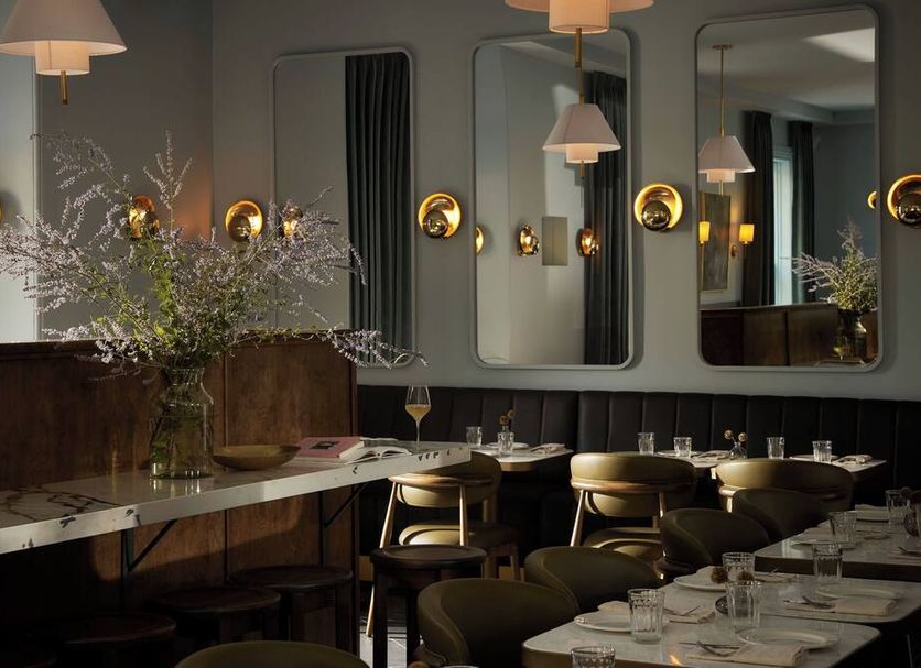 Hotel Belvedere in Kingston dining room with set tables, wall sconces, mirrors, and floral arrangements