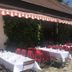 Schloss Diedersdorf outdoor terrace dining with red chairs and white tablecloths in Diedersdorf