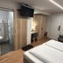 Landhotel Ewerts in Nuerburg guest room with twin beds, TV, desk, armchair and en suite bathroom