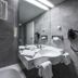 Achat Hotel Monschau bathroom with bathtub, wall-mounted sink, large mirror and towel warmer in Monschau