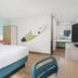 Surf & Sand Hotel Pensacola Beach guest room with king bed, surfboard wall art and desk