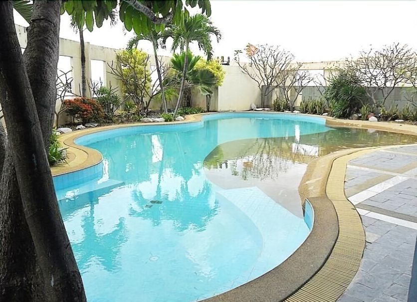 Rachaphruk Grand Hotel in Nakhon Ratchasima with an outdoor swimming pool and palm trees