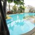 Rachaphruk Grand Hotel in Nakhon Ratchasima with an outdoor swimming pool and palm trees