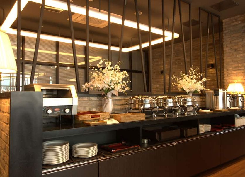 Vella Suite Hotel Suwon breakfast buffet with pastries, fruit, coffee machine and dining counter