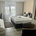 Hotel Hasselberg, Kaiserslautern guest room with double bed, sofa, desk and balcony doors