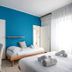 Hc Resort Lignano Sabbiadoro guest room with blue walls, twin beds, desk and bright window