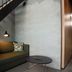 Hotel Guestapart in Aarhus lounge with sofa, round table and staircase against concrete wall