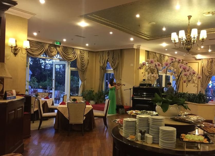 Sammy Dalat Hotel in Dalat dining room with buffet tables, chandeliers and garden-view windows