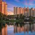 Wyndham Grand Orlando Resort Bonnet Creek waterfront towers reflected in a calm lake at sunset in Celebration
