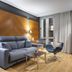 Dorma Juan De Austria in Valladolid: modern hotel suite with sofa, desk, chair and city-view window