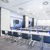 Hampton by Hilton Alcobendas Madrid meeting room with rows of tables, chairs, and wall-mounted screens