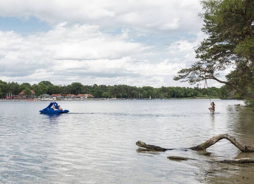 Hotel De Kruishoeve in Vught with a calm lakeside view, blue pedal boat, and trees