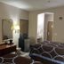 Hotel Piney Woods in Huntsville room with two beds, desk, TV, mirror, and mini fridge