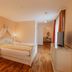 Schlössl Hotel Kindl in Bad Gleichenberg guest room with double bed, wardrobe, TV and wood flooring
