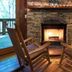 A Cabin In The Woods in Pigeon Forge: stone fireplace with rocking chairs and warm cabin interior