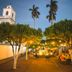 La Casa de Mamapán Hotel Colonial Ahuachapan courtyard at dusk with lit trees and palm silhouettes