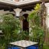 Hotel La Villa Serena in Antigua courtyard with lush plants and a small outdoor table and chairs