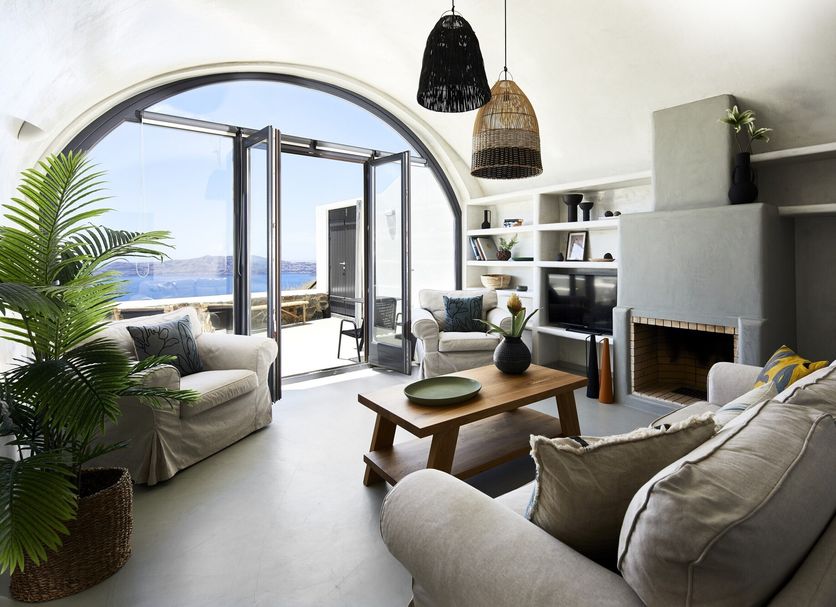 Santorini Princess Spa Hotel in Imerovigli living room with open sea-view doors and fireplace