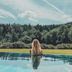 Gut Lauterbad Hotel in Freudenstadt: person in infinity pool overlooking forest and cloudy sky
