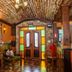 Tiradentes Village lobby with rustic wood, colorful stained-glass doors, and tiled floor in Tiradentes