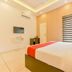 Hotel F Square in Kochi guest room with bed, wall-mounted TV, and striped window blind