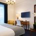 Melia Paris Champs Elysees guest room in Paris with king bed, desk, TV, and balcony doors