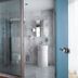 Amadi Park Hotel Amsterdam bathroom with glass shower, pedestal sink, and marble tile