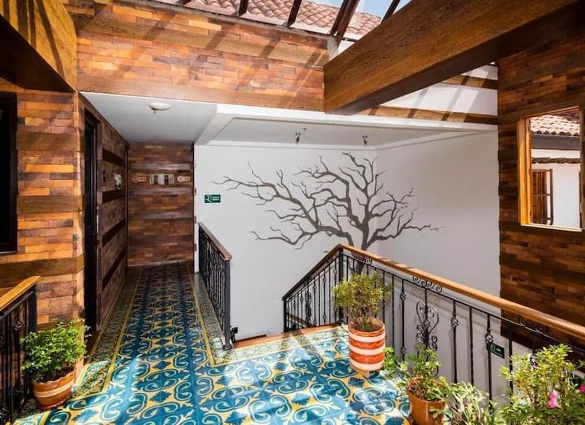 The Cranky Croc Hostel Bogotá interior hallway with colorful tile floor, wooden walls, and staircase