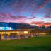 Der Öschberghof in Donaueschingen at sunset, with a lit pool and expansive green lawn