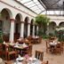 Plaza Magnolias in San Cristóbal de las Casas: covered courtyard restaurant with arched colonnade and tables